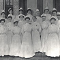 Group of White female Navy nurses taking class photograph in front of building.