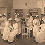 Group of White female nursing students practicing medical techniques on each other.