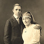 A White female nurse sitting beside a White teenage boy in a suit.
