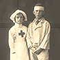 A White girl dressed as a nurse and a White boy with a bandage on his head, looking at the viewer.