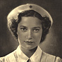 A White female nurse in white, looking at the viewer.
