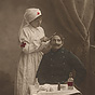 A White female nurse in white treating the head of a White male soldier in blue.