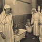 Three White female nurses tend to three White babies, two of which are in tubs.