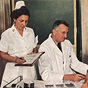 A White female nurse takes notes next to a White male doctor tending to a White male patient.
