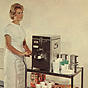 A White female nurse in white pushes a metal food cart to the right.