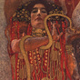 A White female in red and gold holding a snake and a bowl and looking at the viewer.