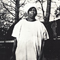 An African American nurse midwife in white, holds a bag and stands in front of a horse.