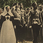 A White uniformed male monarch walks by White soldiers, accompanied by White female nurses.