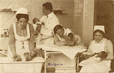 Three White female nurses in white aprons and a White male doctor hold babies.