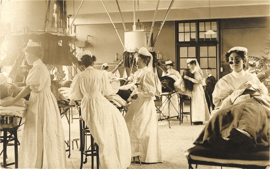 Groups of White female nurses, some wearing goggles, administer treatment to patients