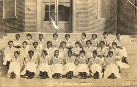 Twenty-six African American female nursing students sitting on steps.