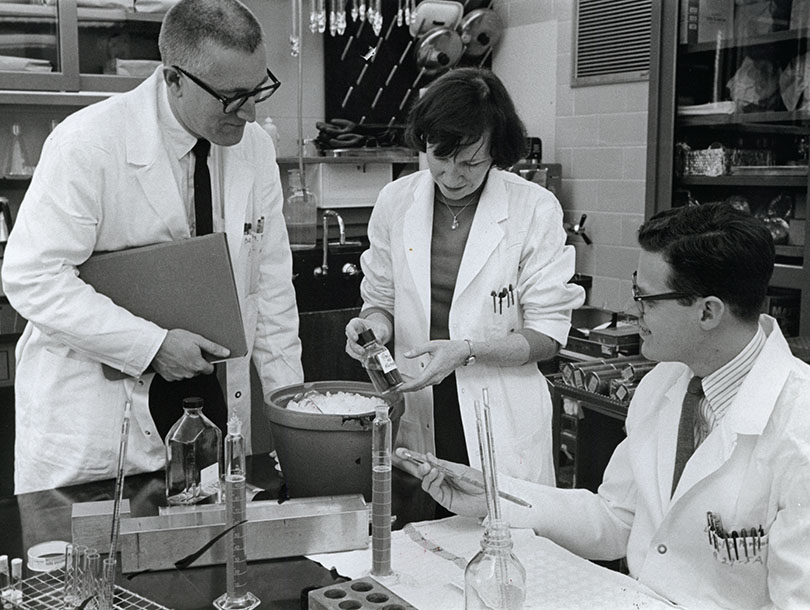 A picture of one woman and three men in a lab