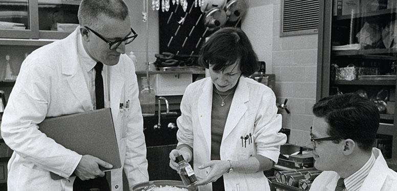 A picture of one woman and three men in a lab