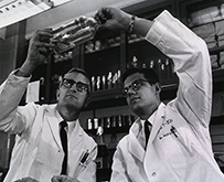 A photograph of two white men in lab coats