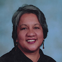 Dr. Linda Susan Aranaydo, an American Indian in a dark shirt smiling for her portrait.