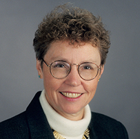Dr. Carol A. Aschenbrener, a White female woman with glasses in a dark suit jacket.