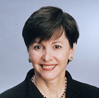 Dr. Linda S. Austin, a White female smiling and standing with her arms crossed in a dark jacket.