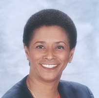 Dr. G. Valerie Beckles-Neblett, a smiling African American female in a red suit jacket with black lapels.