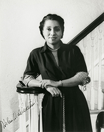 Dr. Helen Octavia Dickens, an African American female posing on a staircase bannister for her portrait.