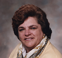 Dr. Nancy Wilson Dickey, a White female in a suit jacket and scarf posing for her portrait.
