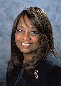 Dr. Janice Green Douglas, a smiling African American female in a suit jacket posing for her portrait.