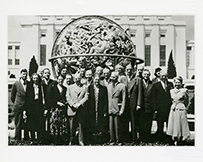 Dr. Martha May Eliot, center, a White female, posing outdoors in front of a globe with delegates to the first World Health Assembly, in front of the United Nations, Geneva, Switzerland, 1948.
