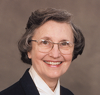 Dr. Lois Taylor Ellison, a smiling White female with glasses in a dark jacket posing for her portrait.
