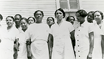 Dr. Dorothy Ferebee, center, an African American female in light-colored attire posing with the Mississippi Health Project staff, 1937.