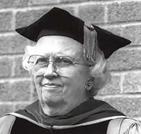 Dr. M. Irené Ferrer, a White female in a cap and gown posing for a portrait.