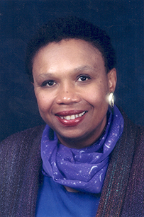 Dr. Vanessa Northington Gamble, an African American female in a purple scarf smiling for her portrait.