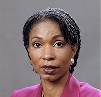 Dr. Helene D. Gayle, an African American in a bright pink suit posing for her portrait.