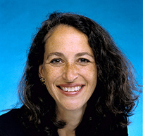 Dr. Margaret Hamburg, smiling a White female posing for her portrait against a blue background.