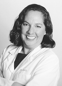 Dr. Susan Veronica Karol, a smiling White female wearing a lab coat posing for her portrait.