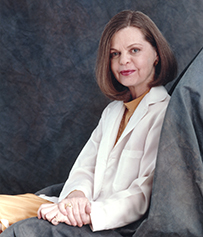 Dr. Marianne J. Legato, a White female in a blouse posing with gray studio drapes for her portrait.