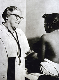 Dr. Edith M. Lincoln, a White female wearing a lab coat and stethoscope next to a child seated on a table.