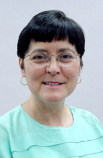 Dr. Theresa Loya, a White female with glasses smiling for her portrait.