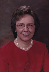 Dr. Barbara J. McNeil, a White female in a red suit and pearls posing for her portrait.