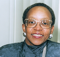 Dr. Janet L. Mitchell, a smiling African American female in a blue blouse and pearls.