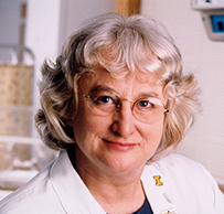 Dr. Jennifer R. Niebyl, a White female with glasses and in a lab coat posing for her portrait.