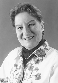 Dr. June E. Osborn, a White female in a flower-print blouse posing for her portrait.