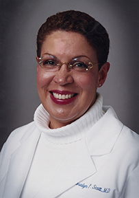 Dr. Rosalyn P. Scott, an African American female posing in her lab coat, smiling for her portrait.
