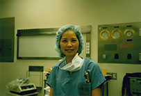 Dr. Linda Dairiki Shortliffe, a Japanese American female, in scrubs and a cap posing inside a surgery room. 