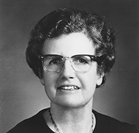Dr. Caroline Bedell Thomas, a White female wearing a long necklace and glasses posing for her portrait.