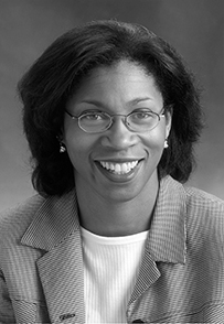 Dr. Terri L. Young, an African American female in a suit and glasses smiling for her portrait.
