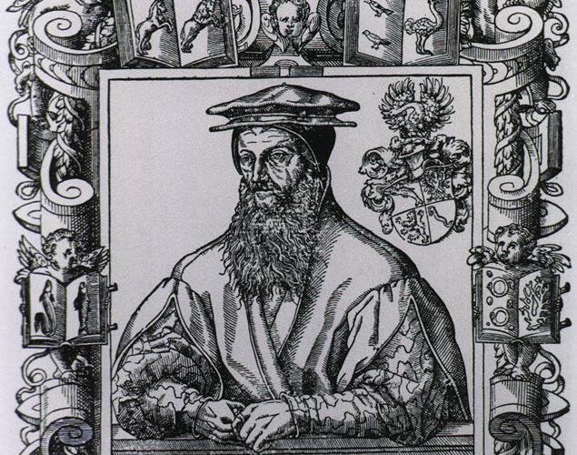 Portrait of a man in a robe with his arms folded in front.