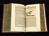 Pages of book with Latin text and illustration of a long horned unicorn prancing.