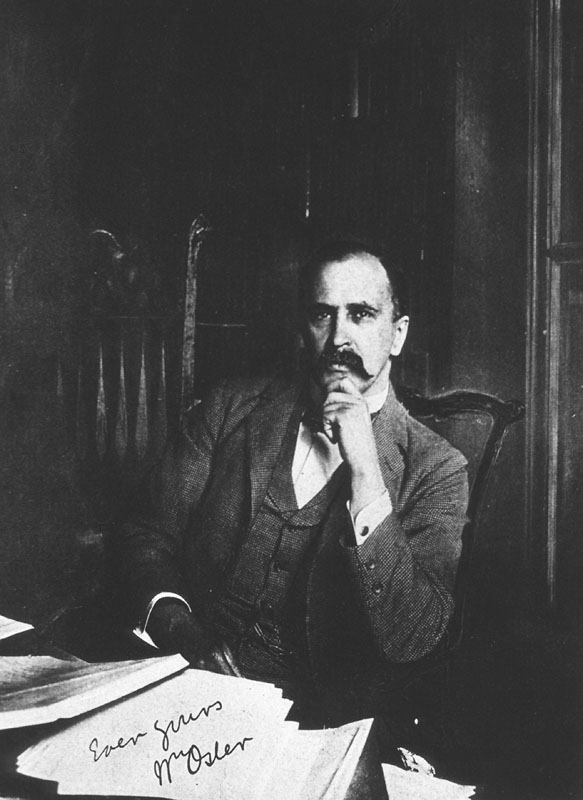 Black and white half length, full face, seated at desk covered with books and papers, hand to chin of William Osler.