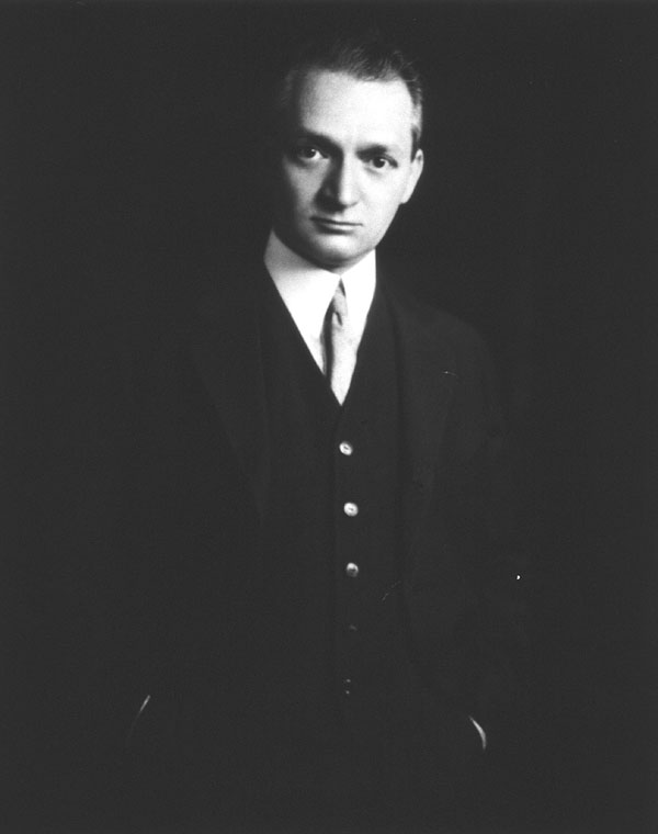 A black and white photograph of the .Victor Robinson standing, three quarter length, front; hands in pockets.