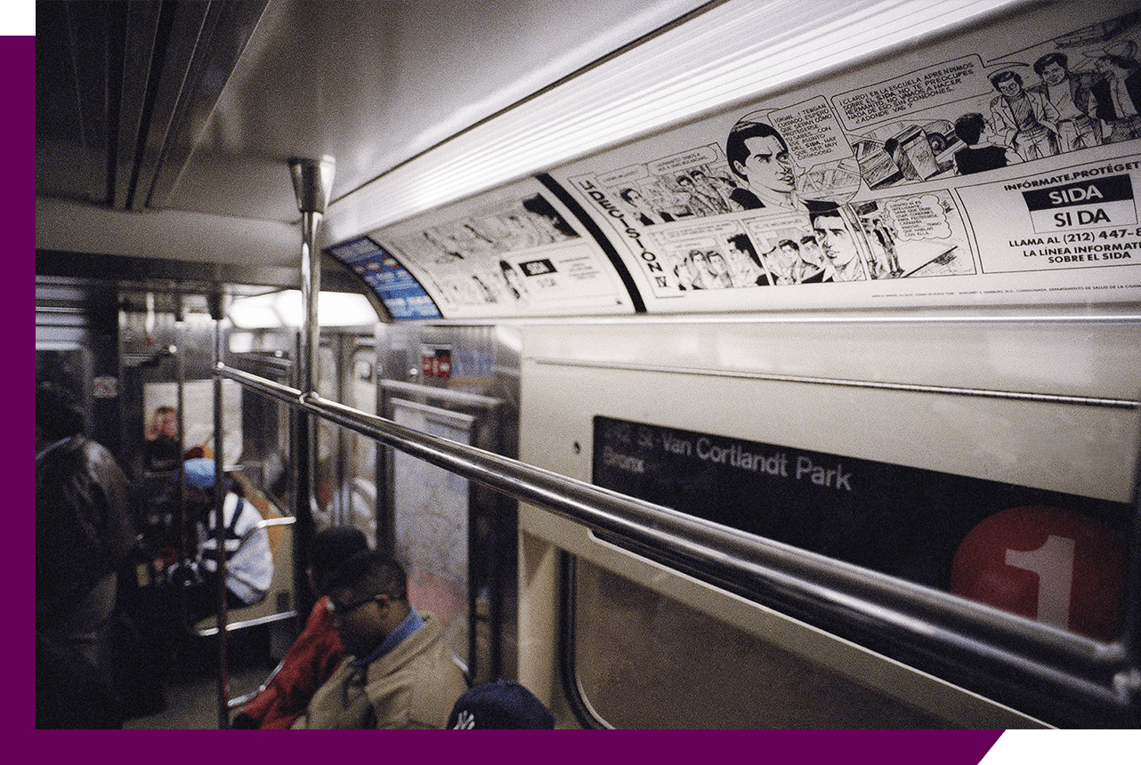 New York City subway interior, white and black La Decisión comic panels along ceiling of car.