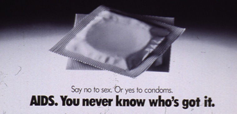Black and white photograph of two condoms in a spotlight.